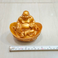 Patung Buddha tertawa, laughing Buddha duduk di atas uang emas/ingot