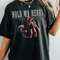 May include Black t- shirt with a graphic print of a hand holding a bloody heart. The text HOLD MY H