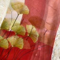 Amora-Amora Luxe Shawl dengan Motif Daun Emas pada Background Merah